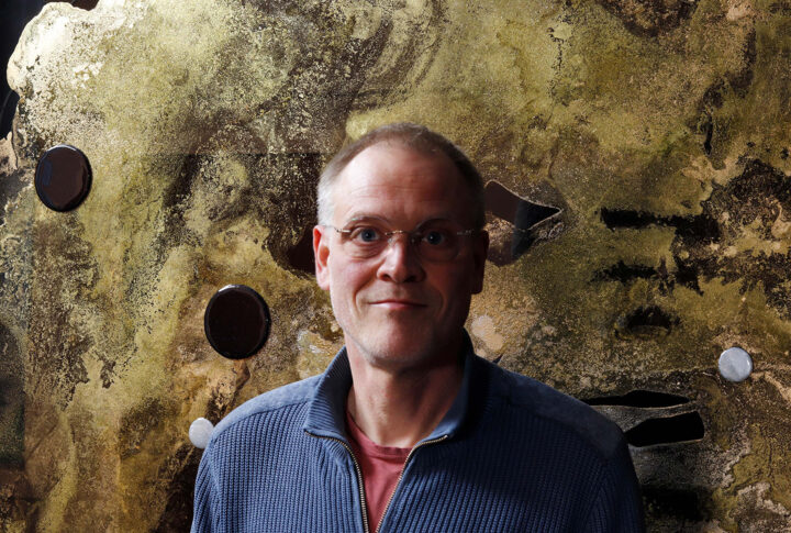 Portrait of Stephan Konings in front of one of his paintings.